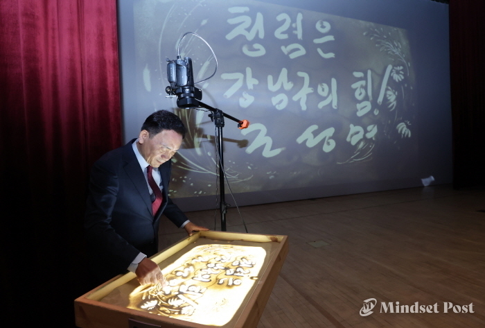 샌드아트 모래판에 청렴의 가치를 강조하는 메시지를 남기고 있는 조성명 강남구청장. (사진제공 강남구)